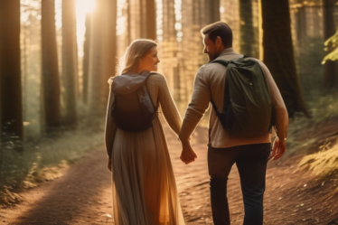 Ein Paar wandert Hand in Hand durch einen dichten Wald in Deutschland.
